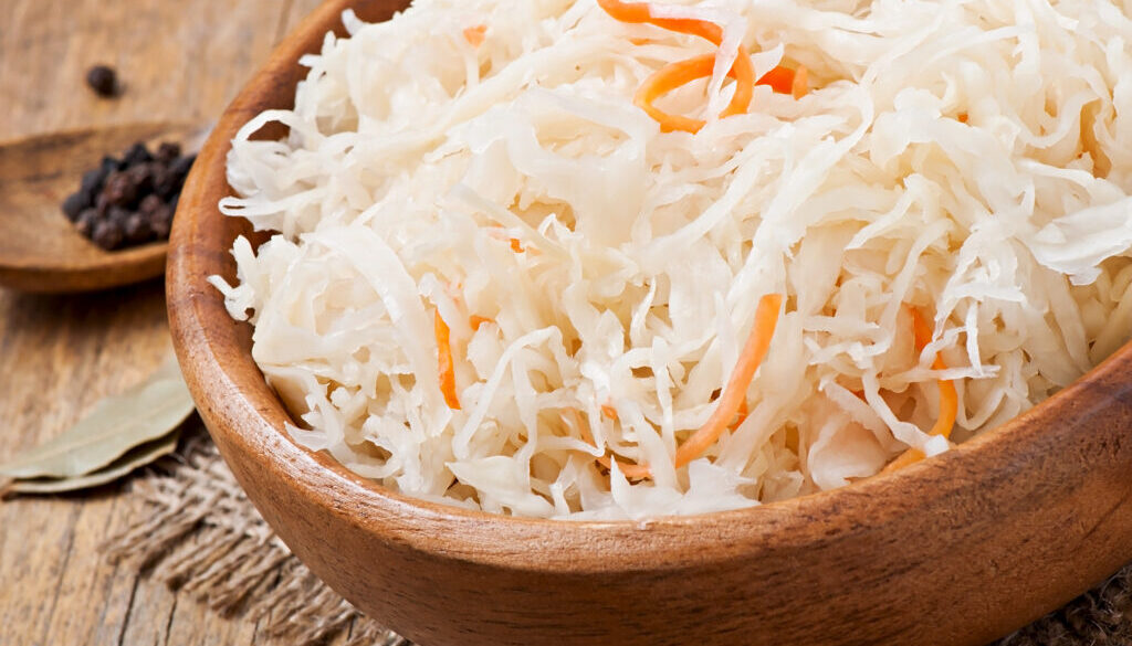 Sauerkraut with carrot in wooden bowl