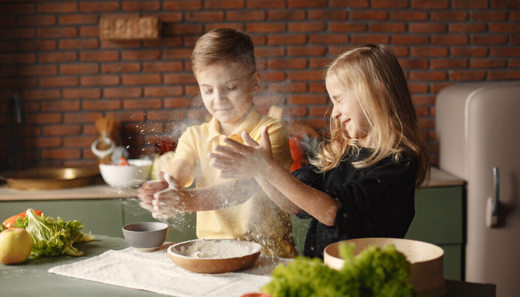 Children playing with a flour in a kitchen